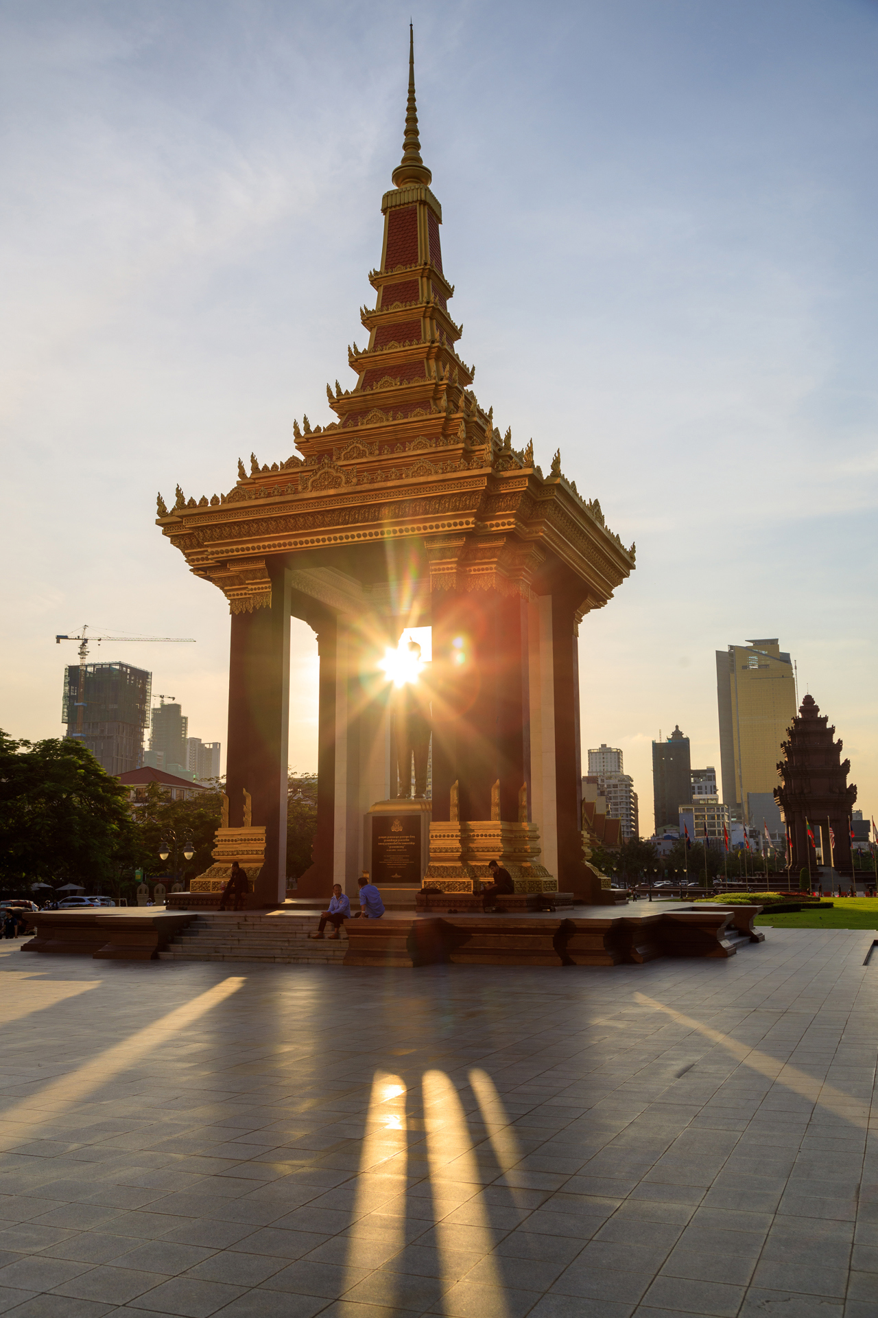 Sun shining through a temple with a statue in the middle
