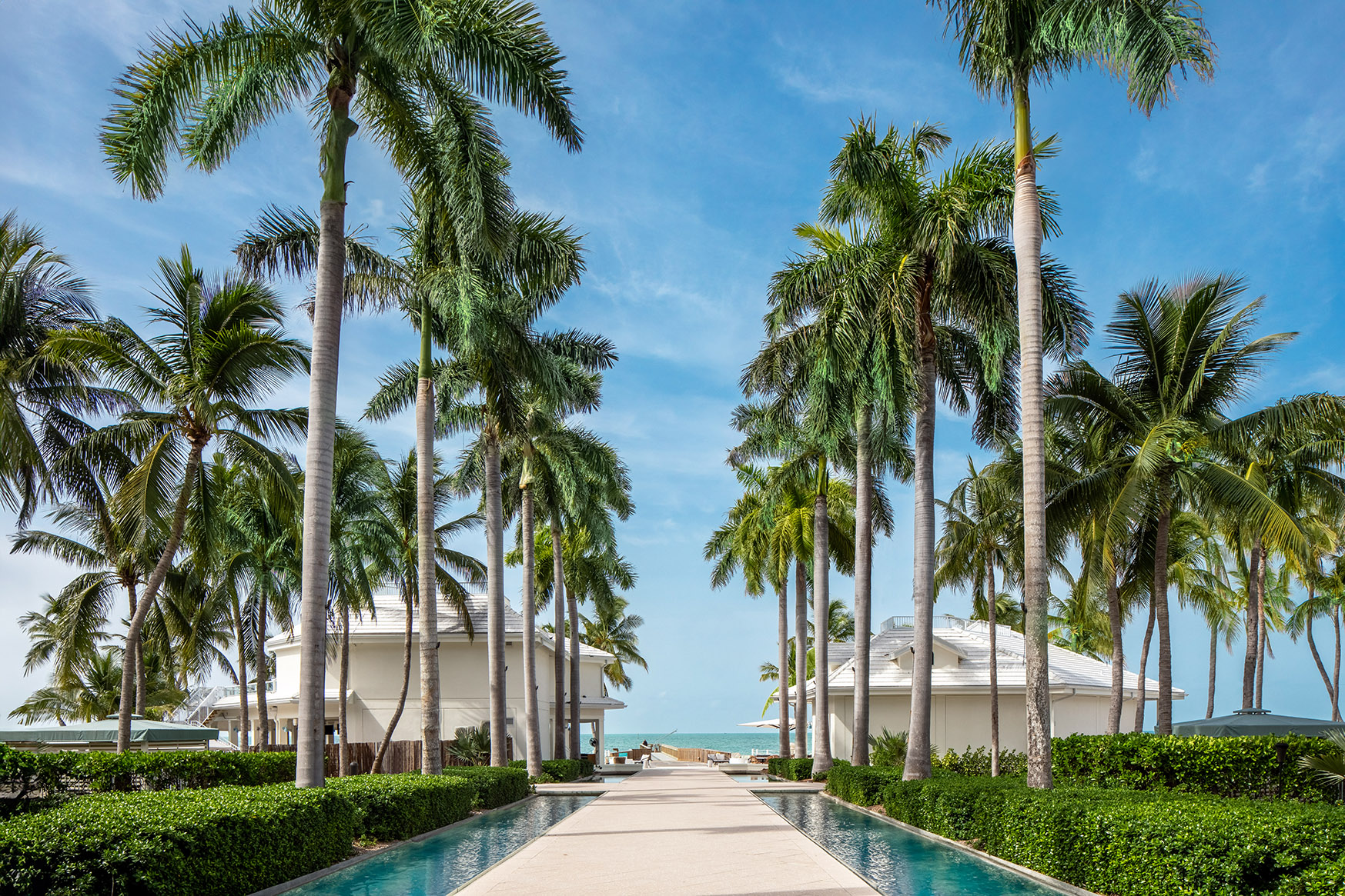 A walkway to the beach flanked on either side by water and palm trees at Casa Marina Key West, Florida 