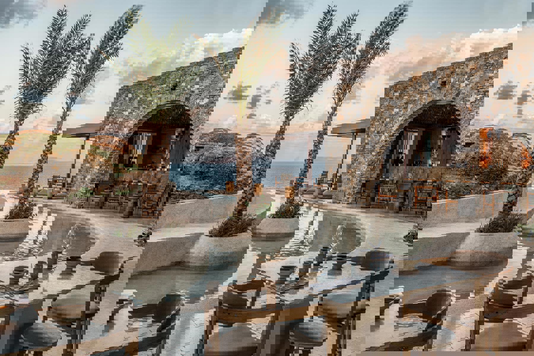 Pool surrounded by palm and the bar at Acro Wellness