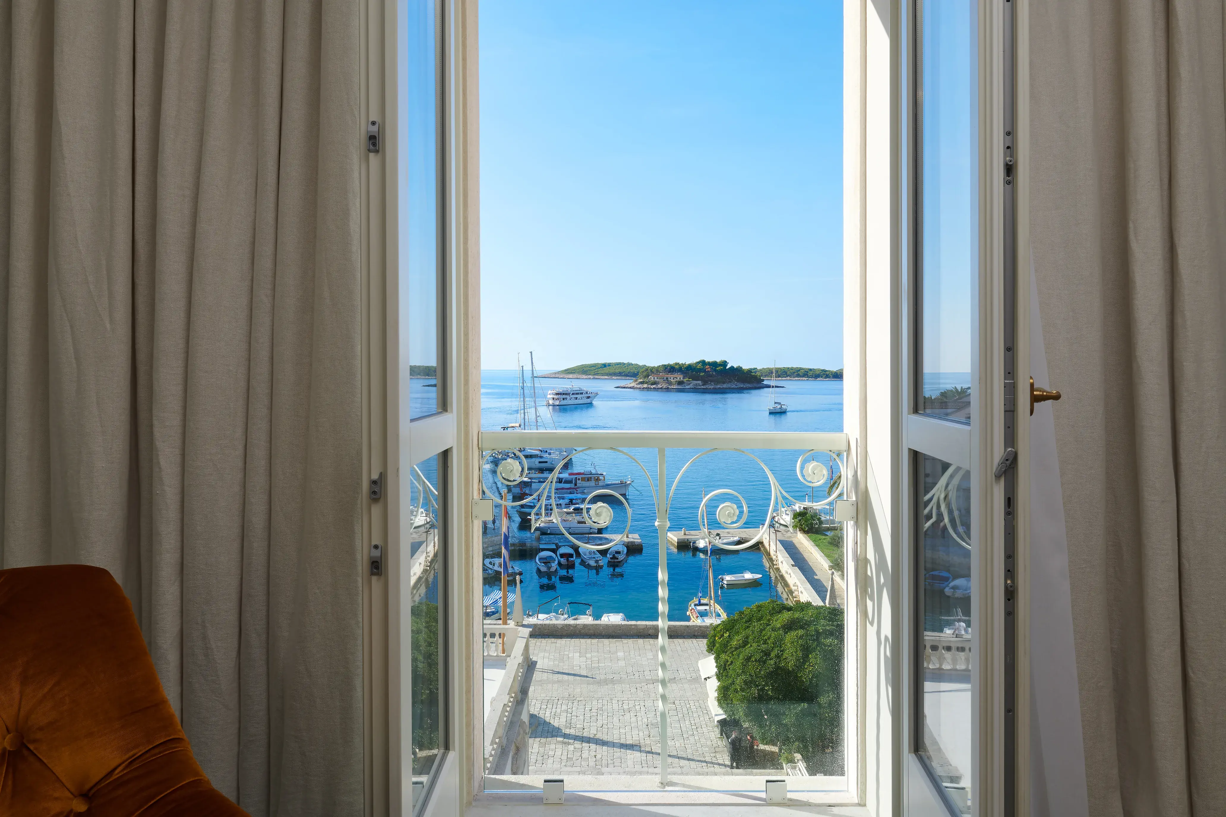 Balcony of a Deluxe Suite Sea View at Palace Elisabeth in Croatia featuring open French doors leading to a balcony overlooking the harbour and sea