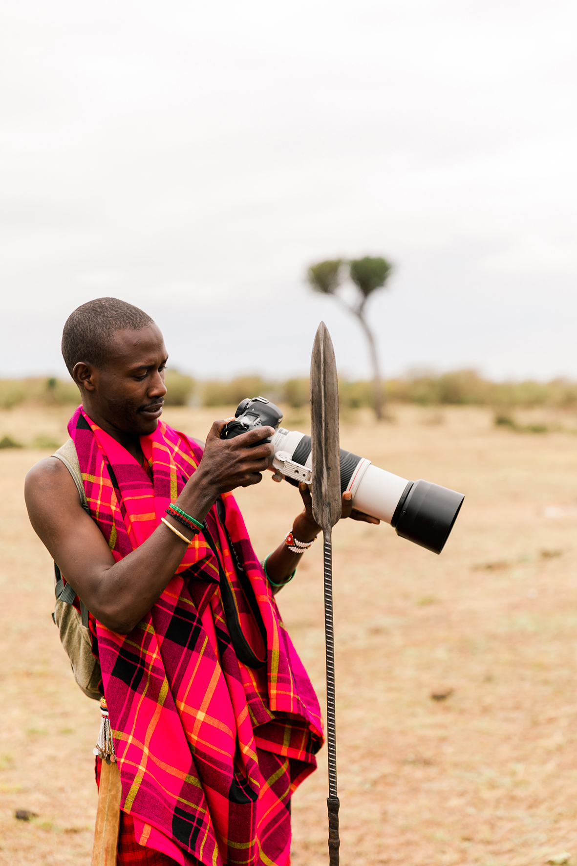 Maasai Mara guide in tradiitonal attire holding a camera