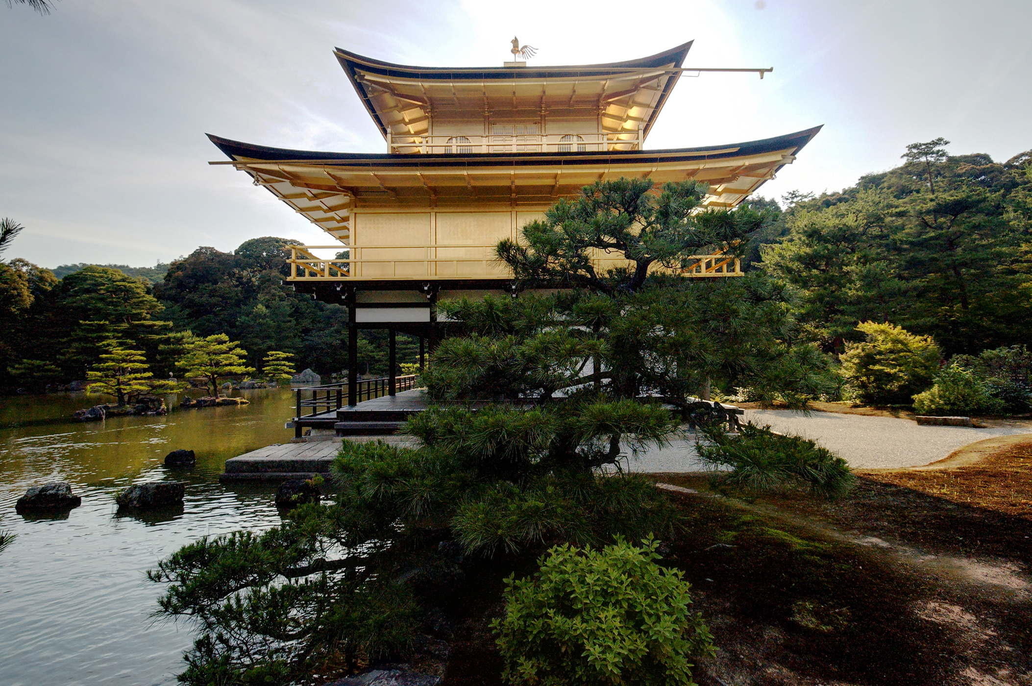 The Kinkakuji Temple (Golden Temple) in Kyoto on the banks of a lake surrounded by trees