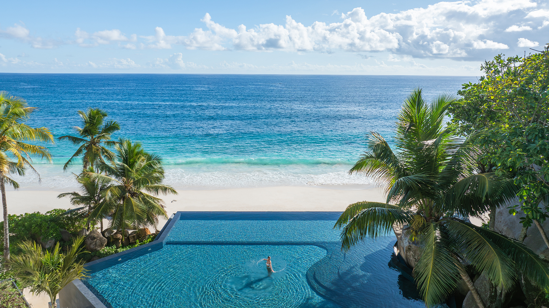 Indian Ocean, Seychelles, Cheval Blanc, Woman in Main Pool with View of Beach