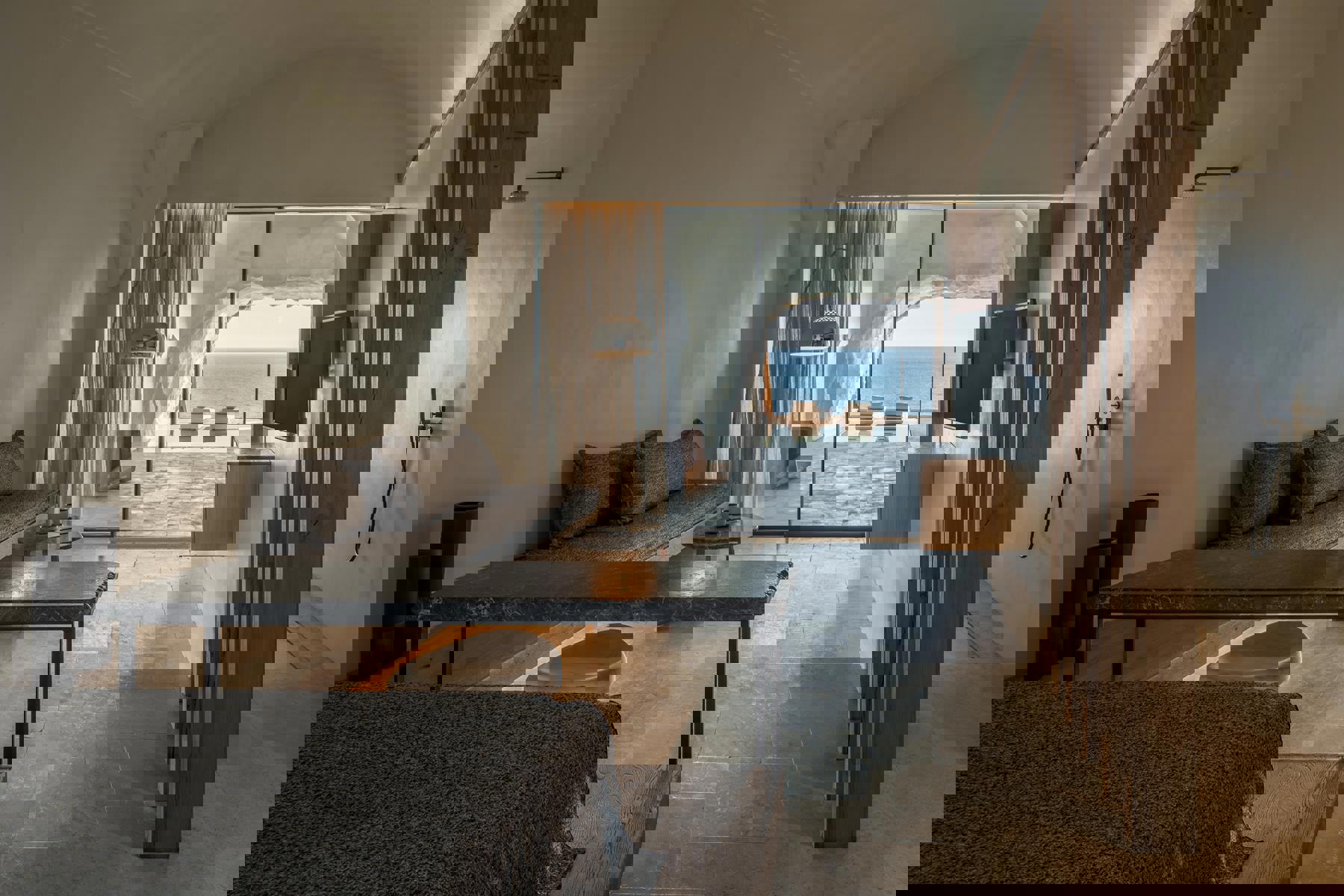 Lounge area leading out to private pool and loungers in a Cave Suite