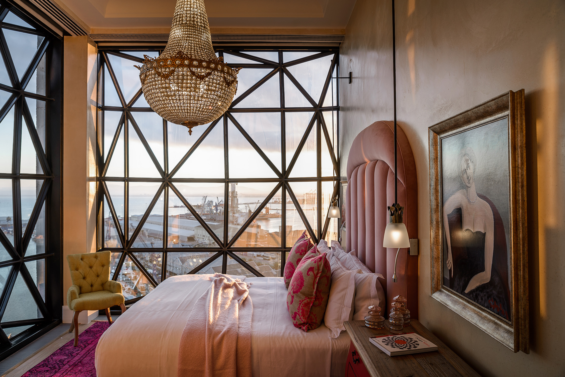 Luxury Royal Suite at The Silo Hotel in Cape Town with panoramic harbor views, elegant chandelier, and artistic décor.