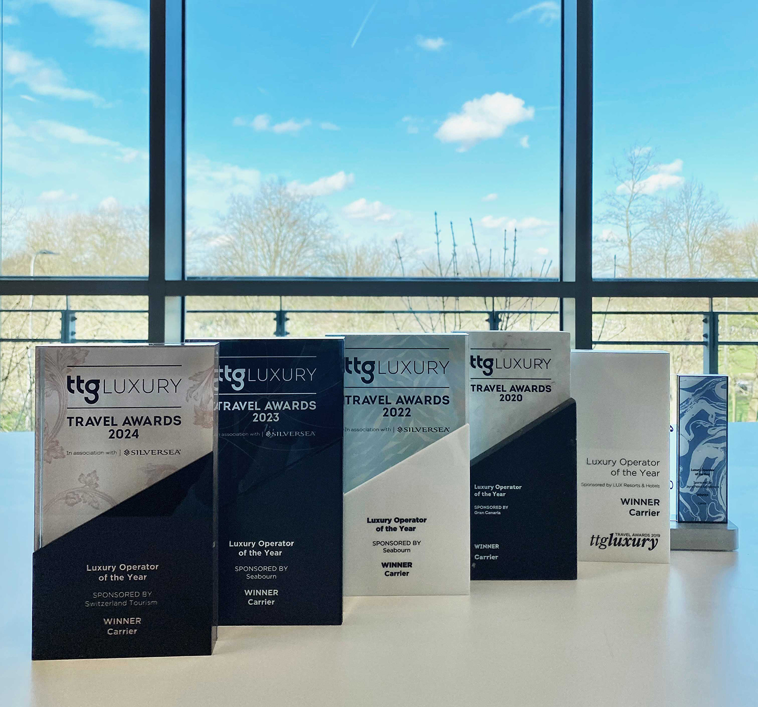 Lineup of Carrier's six trophies for TTG Luxury Operator of the Year