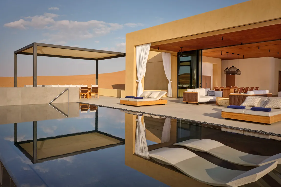 Spacious outdoor terrace of two-bedroom villa at Ritz-Carlton Ras Al Khaimah, Al Wadi Desert featuring private pool, sun loungers, and desert views.