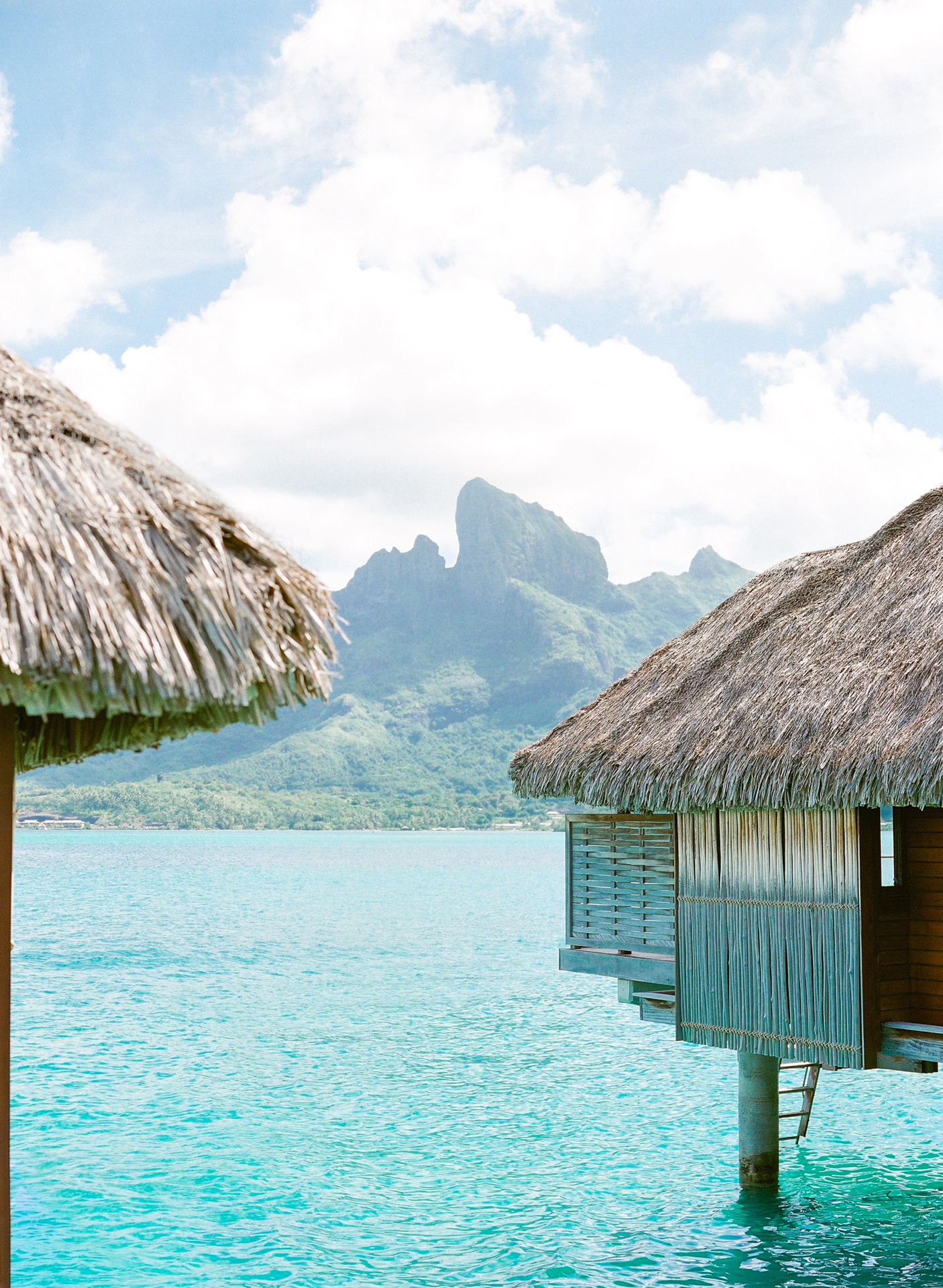 Overwater bungalows in Bora Bora with a mountain in the background