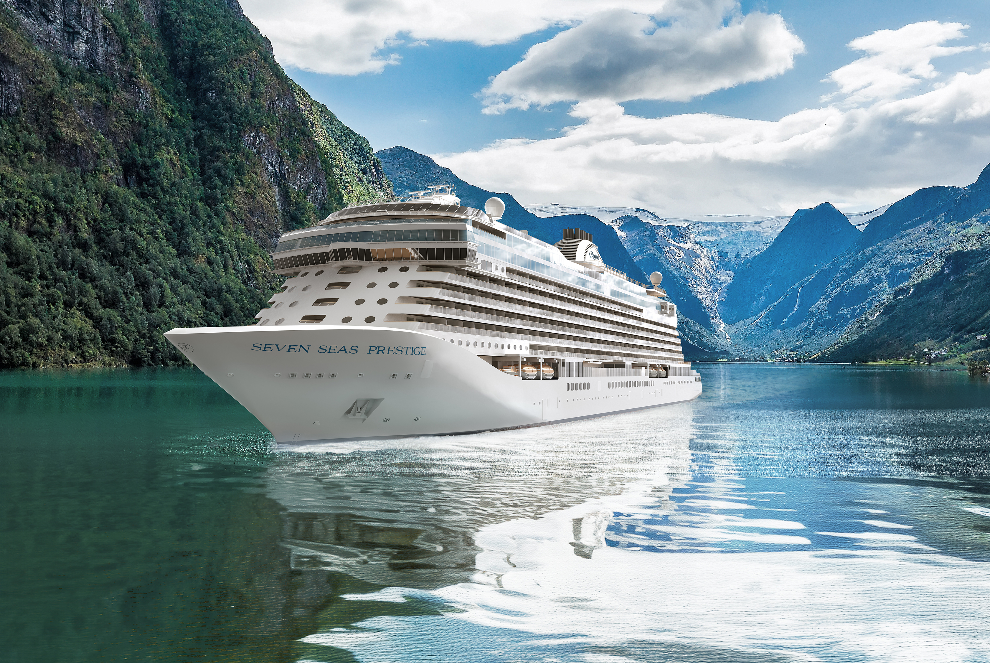 The exterior of Seven Seas Prestige anchored in the ocean flanked by tall mountains