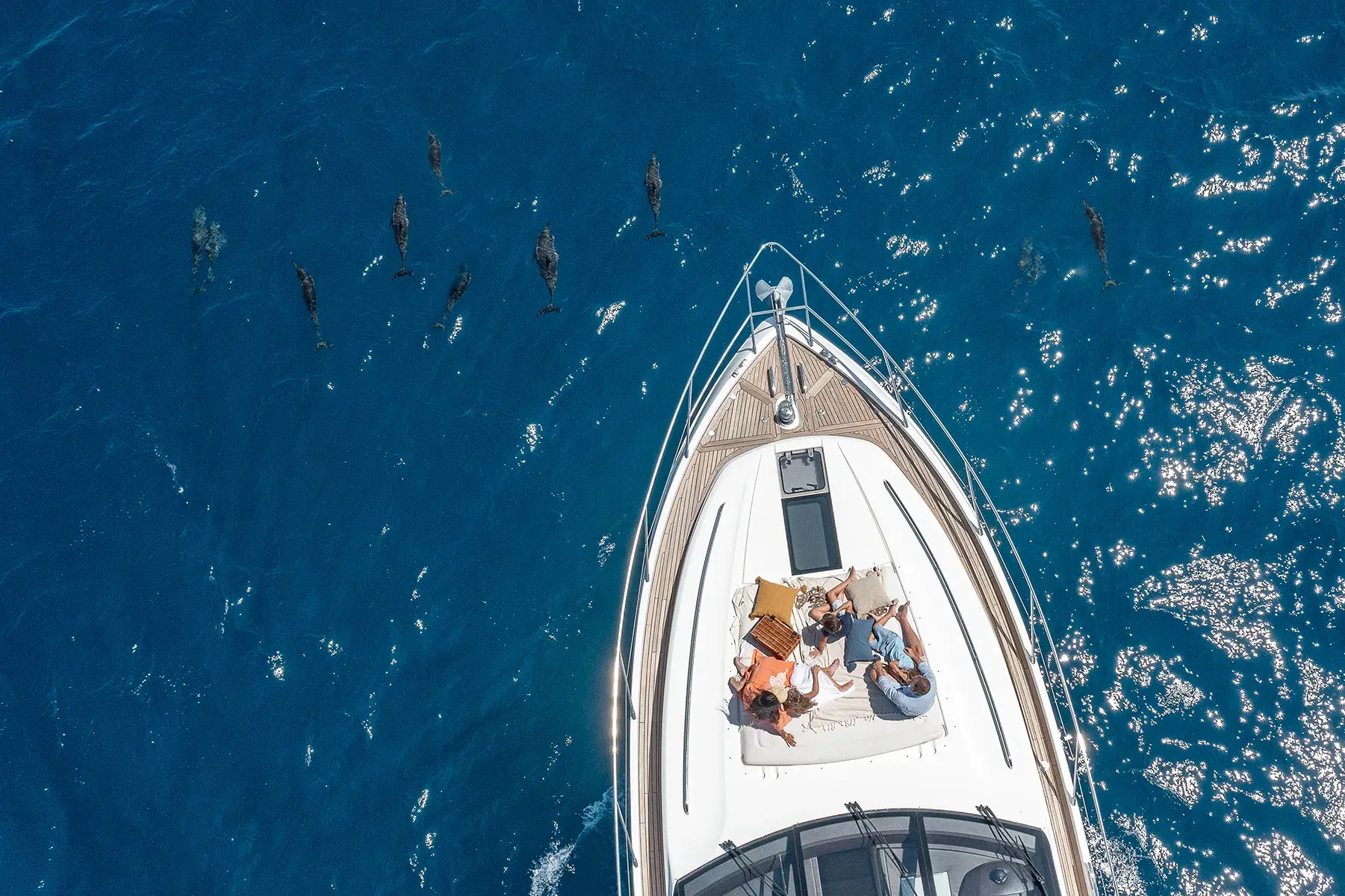 Family enjoying luxury dolphin cruise on a yacht in crystal-clear blue ocean waters at The Nautilus Maldives.