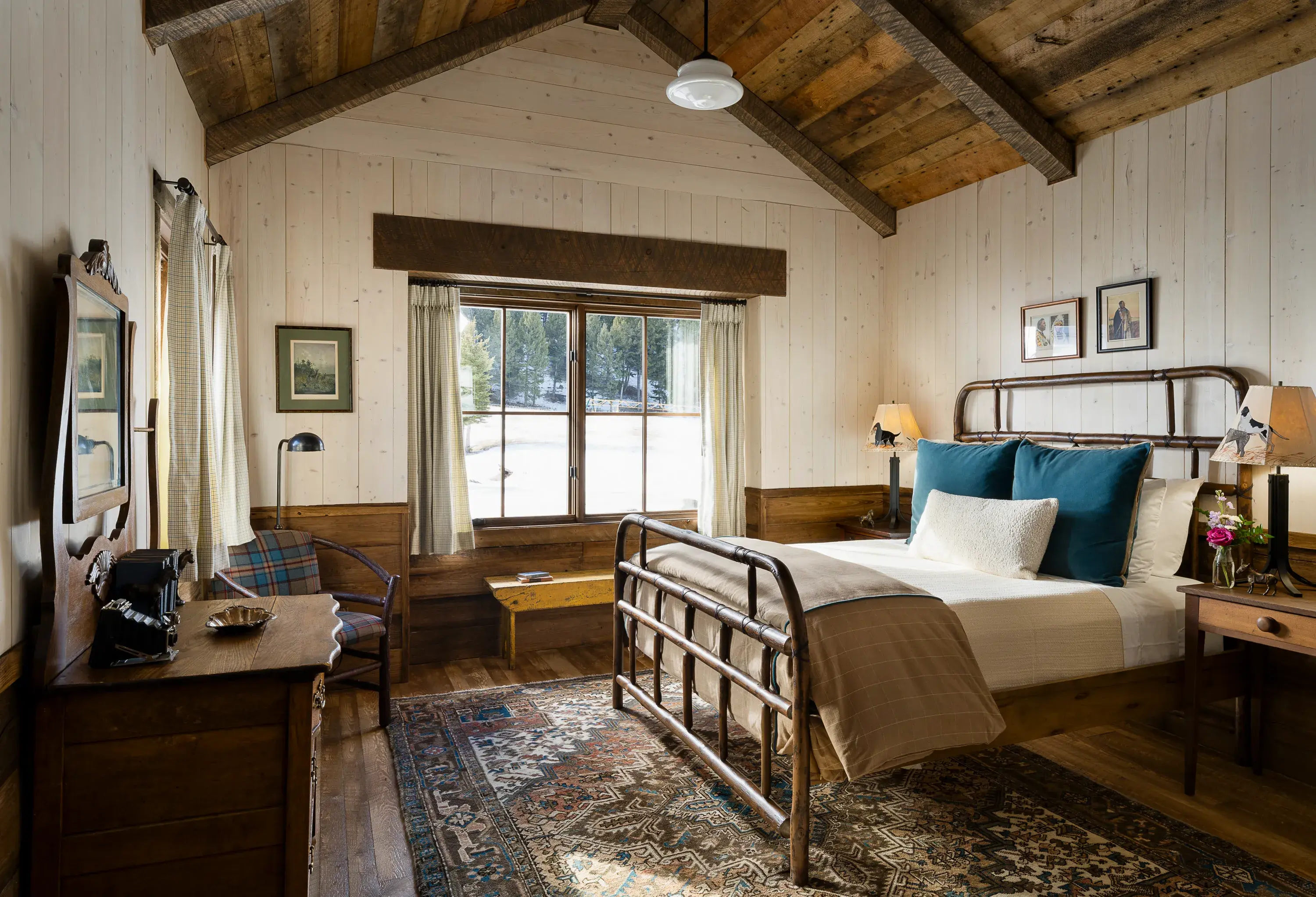 Bedroom of Golden Eagle Cabin at The Ranch at Rock Creek in Montana featuring ranch-style furniture beneath vaulted ceilings with a window looking onto the wilderness