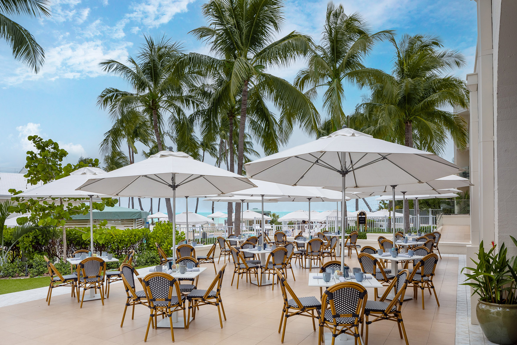 Tables of 4 under parasols on the terrace at Flagler S restaurant at Casa Marina Key West, Florida