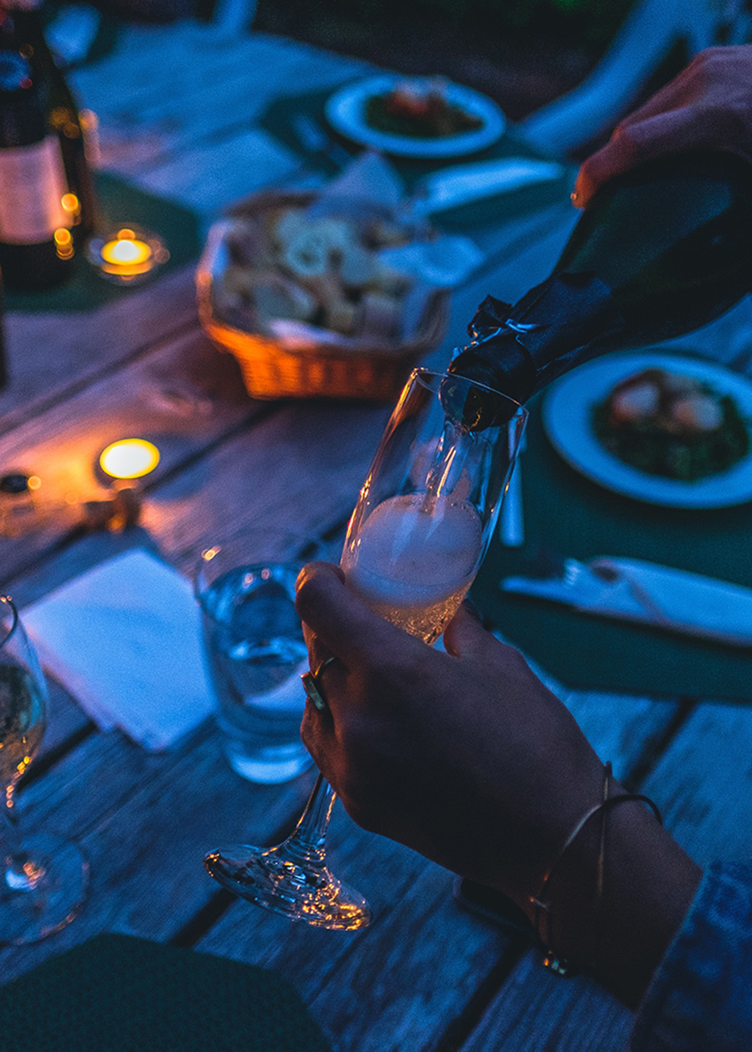 Evening shot of woman pouring a glass of champagne