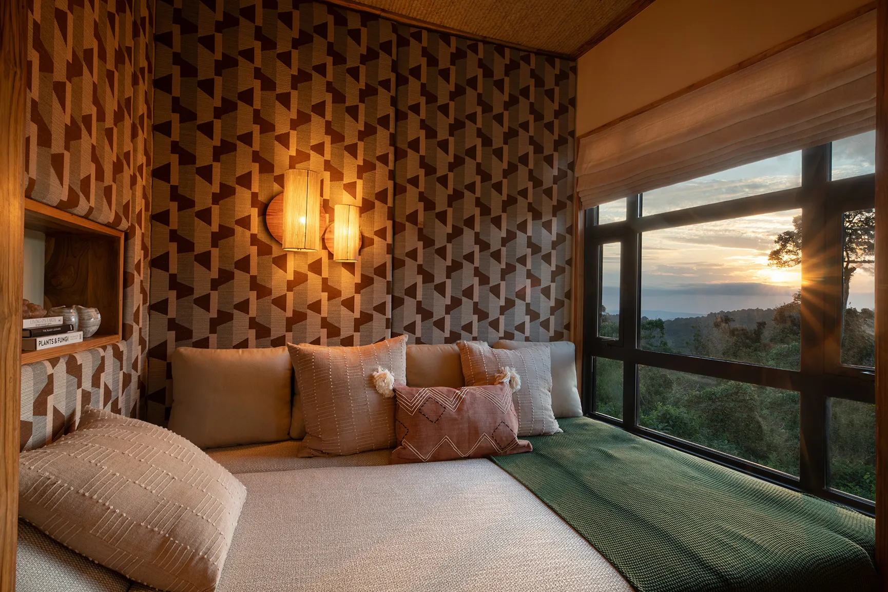 Lodge bedroom with a floor to ceiling window overlooking forest views