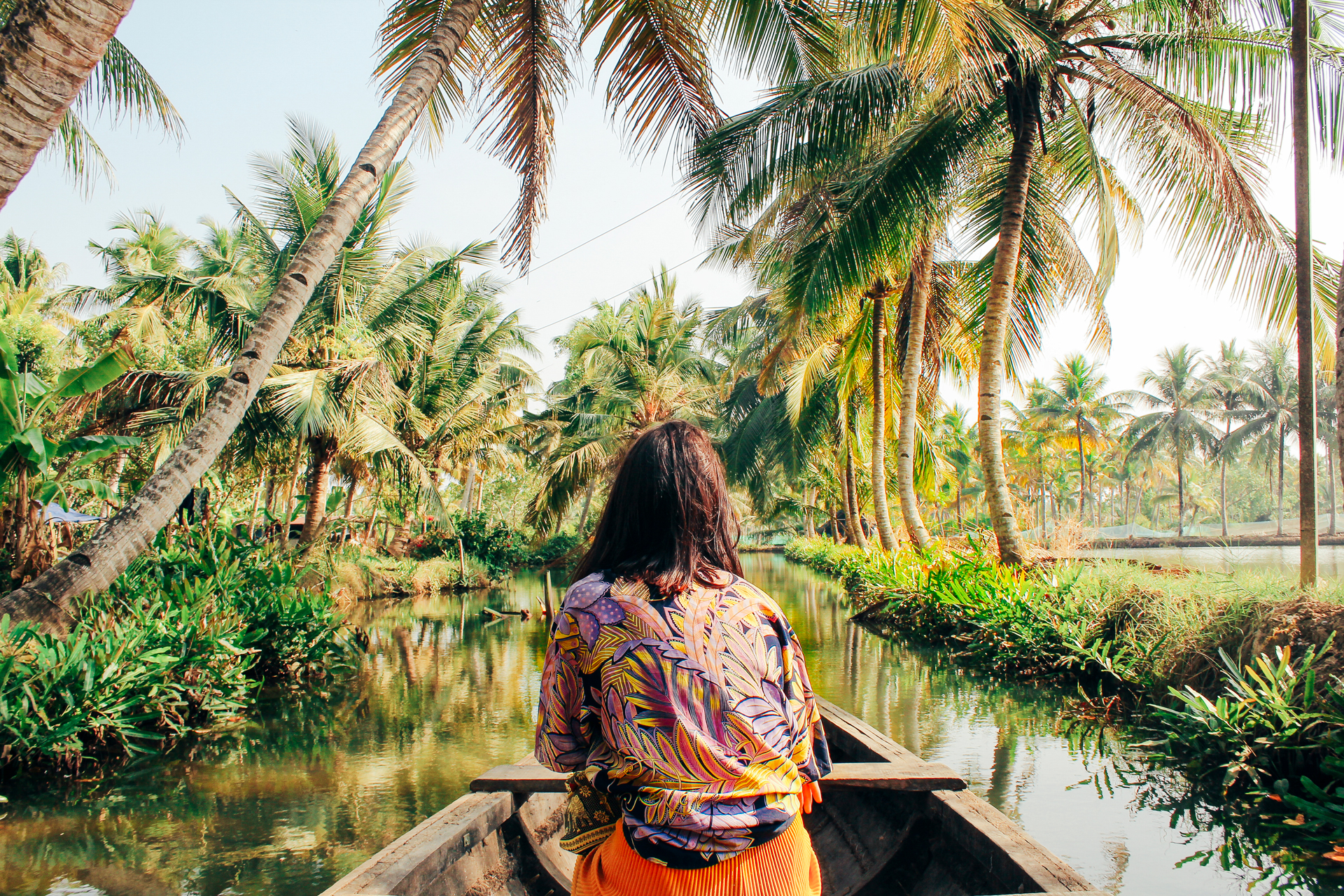 a person in a boat on a river surrounded by trees