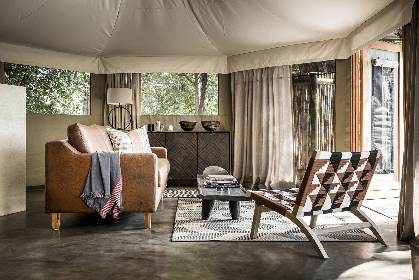 Africa, Zambia, Sungani Lodge, living space in a tented suite made up of a sofa, chair and coffee table