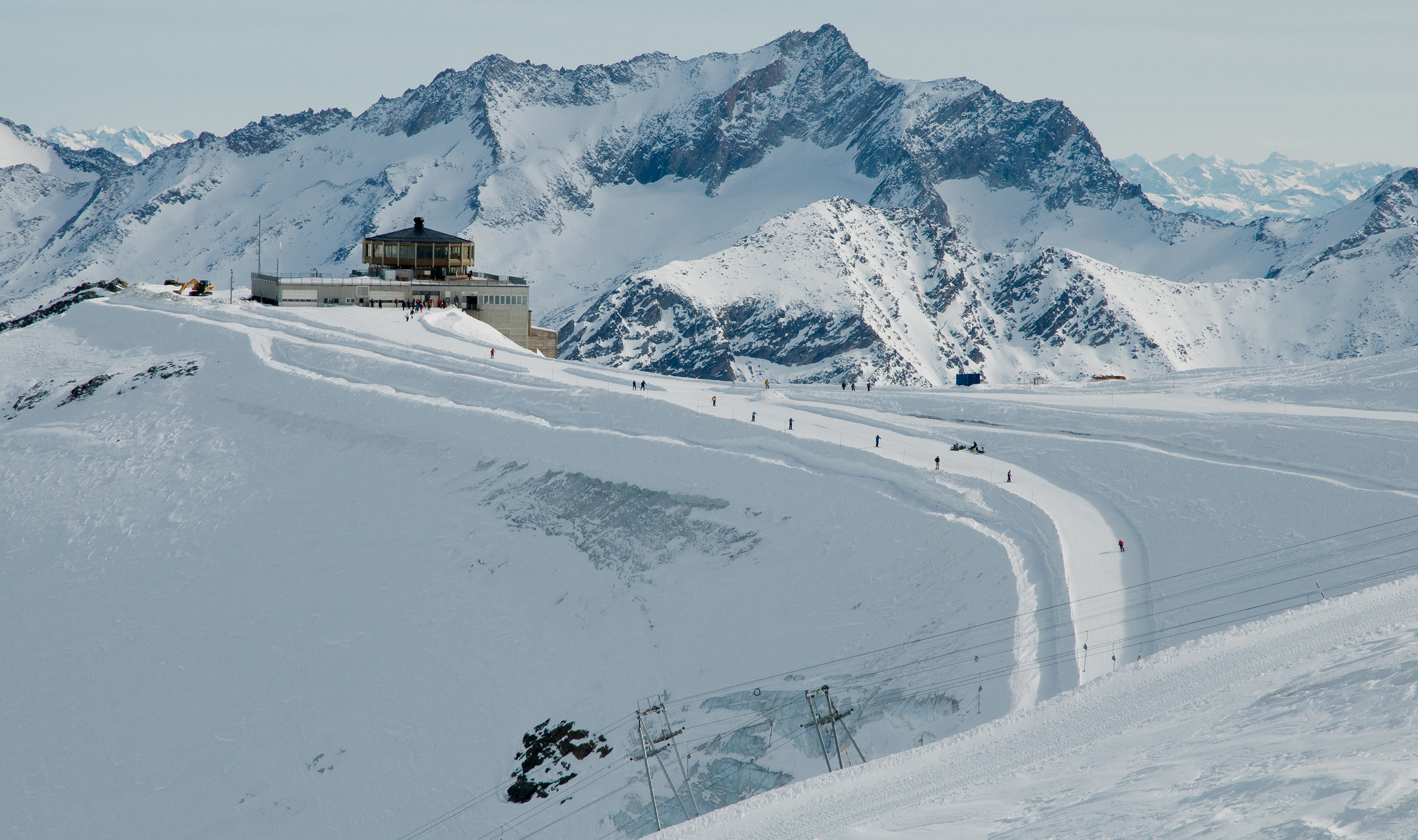 Skiers heading up a snowy hill to Restaurant Allalin in Saas-Fee Switzerland