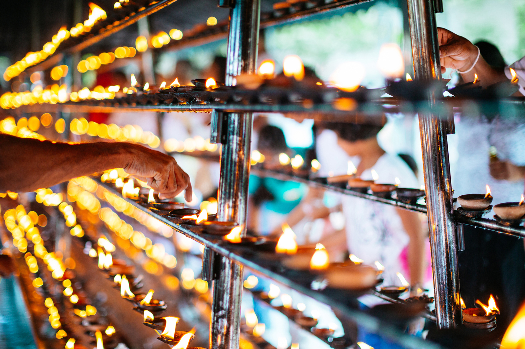 Hand lighting candles in Sri Lankan temple