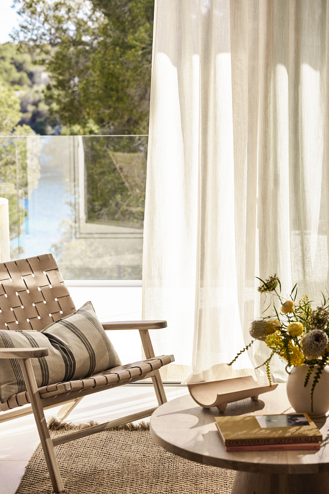 Europe, Spain, Mallorca, Ikos Porto Petro, deluxe one bedroom chair and coffee table with flowers and books