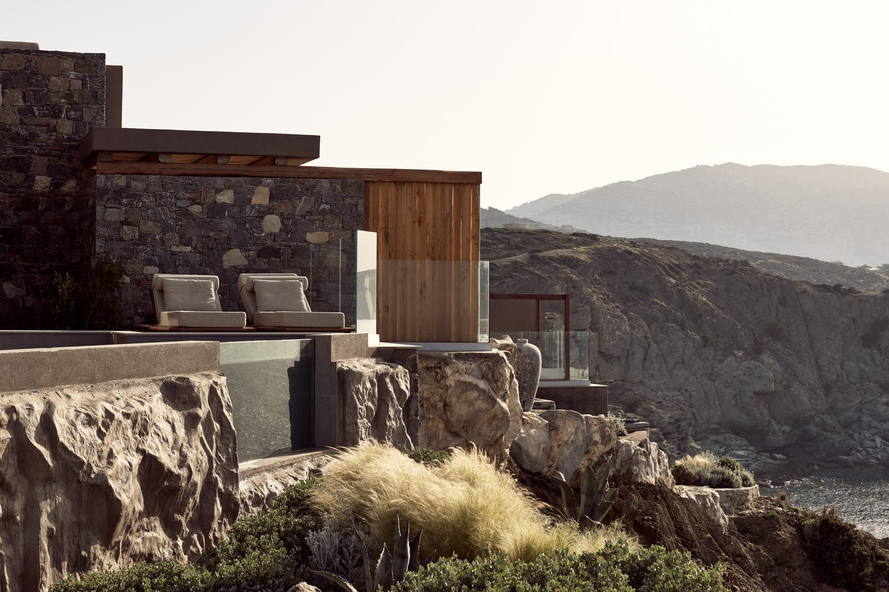 Loungers and infinity pool carved into the cliff at Acro Wellness