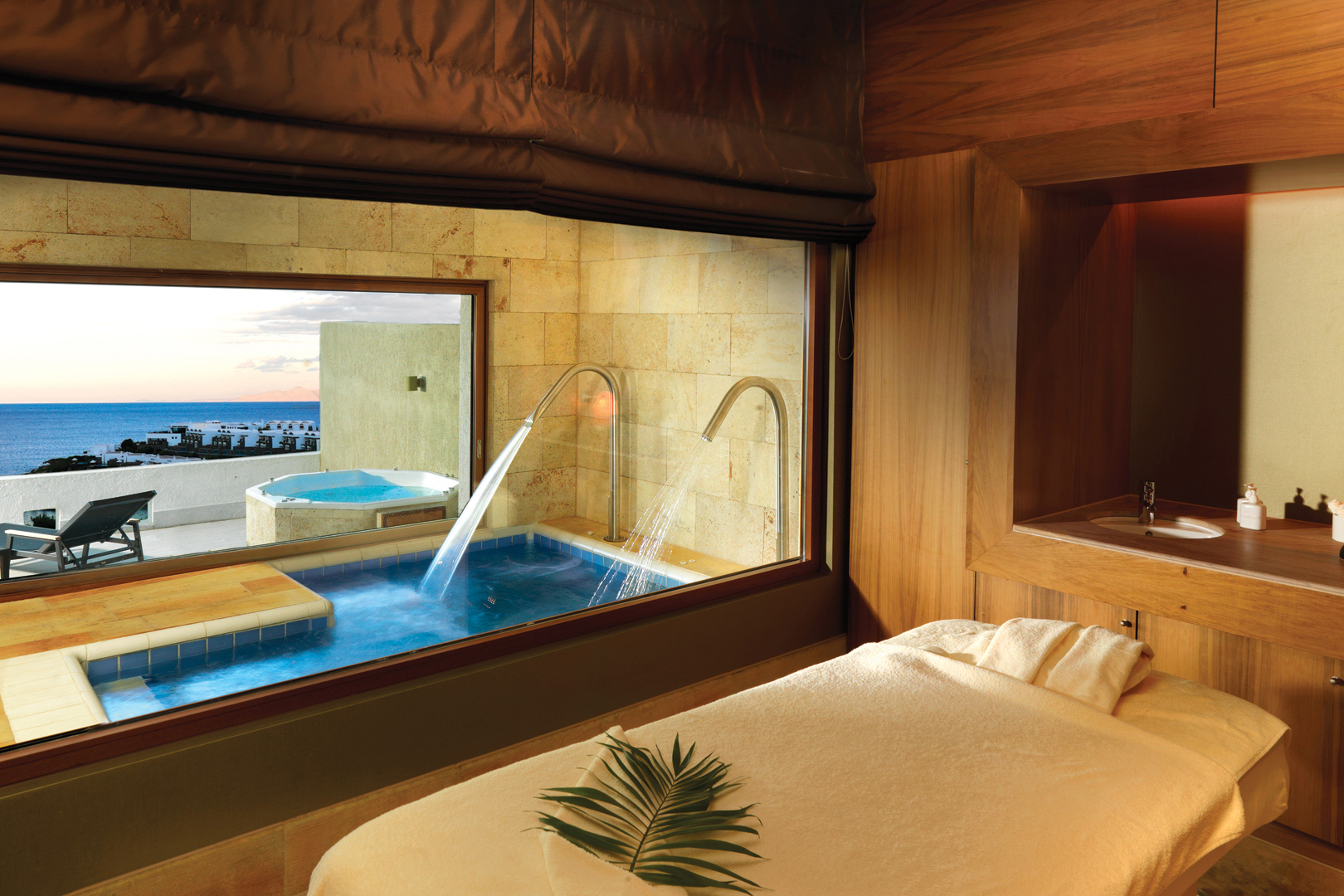 White spa bed with leaf decoration and plunge pool outside with water massage taps