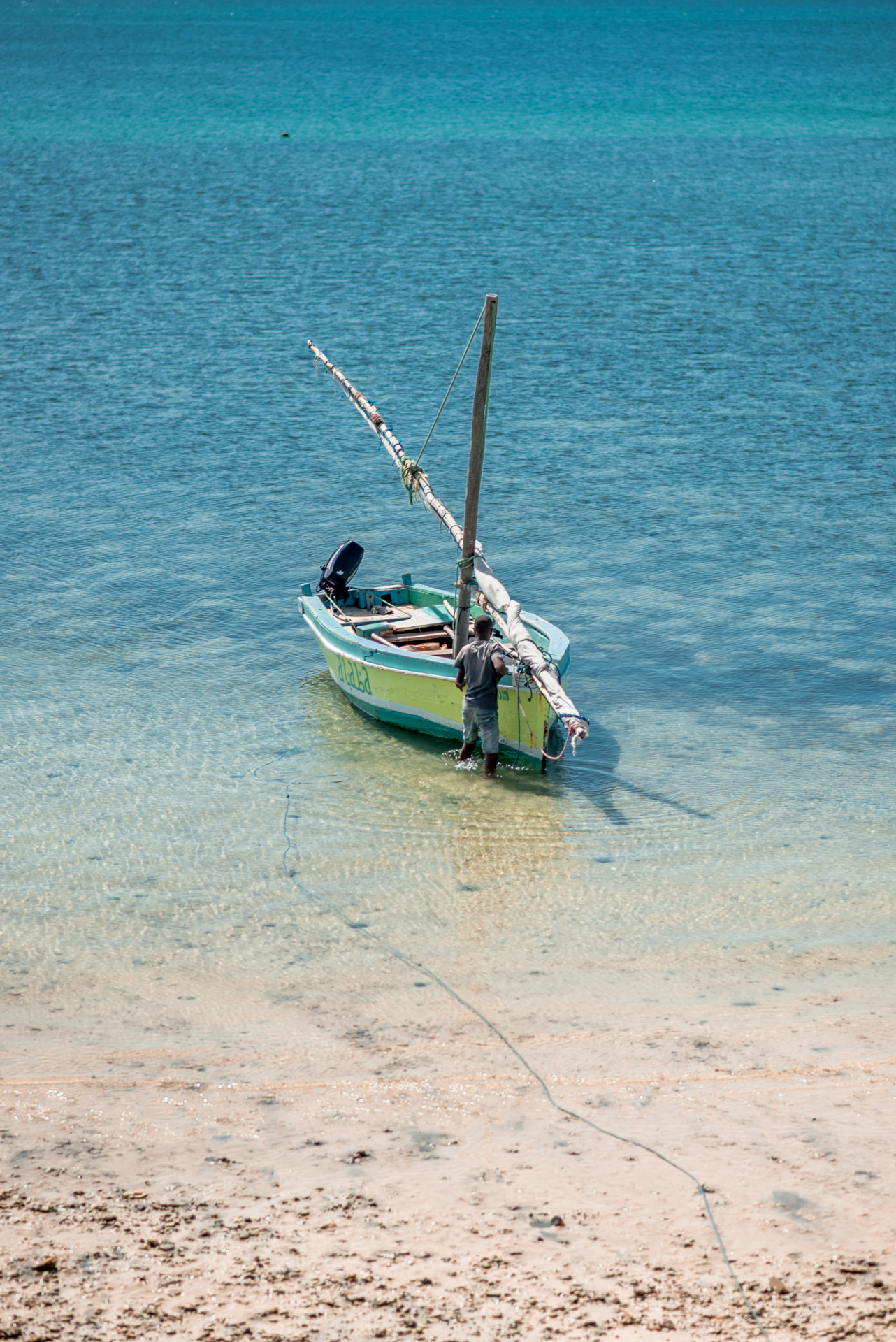 A man tending to a boat at waters edge
