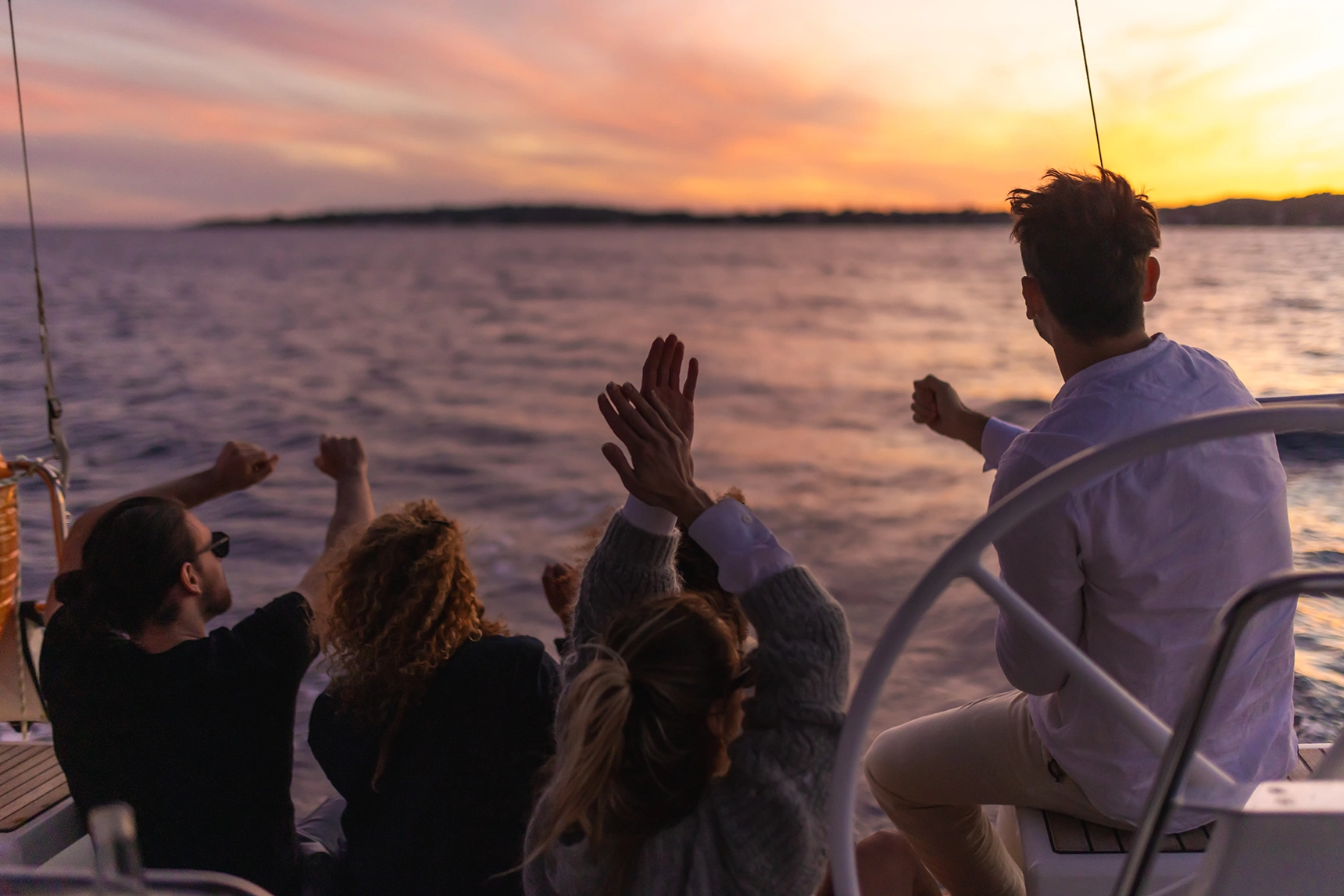 A group of people watching the sunset on a luxury private yacht 