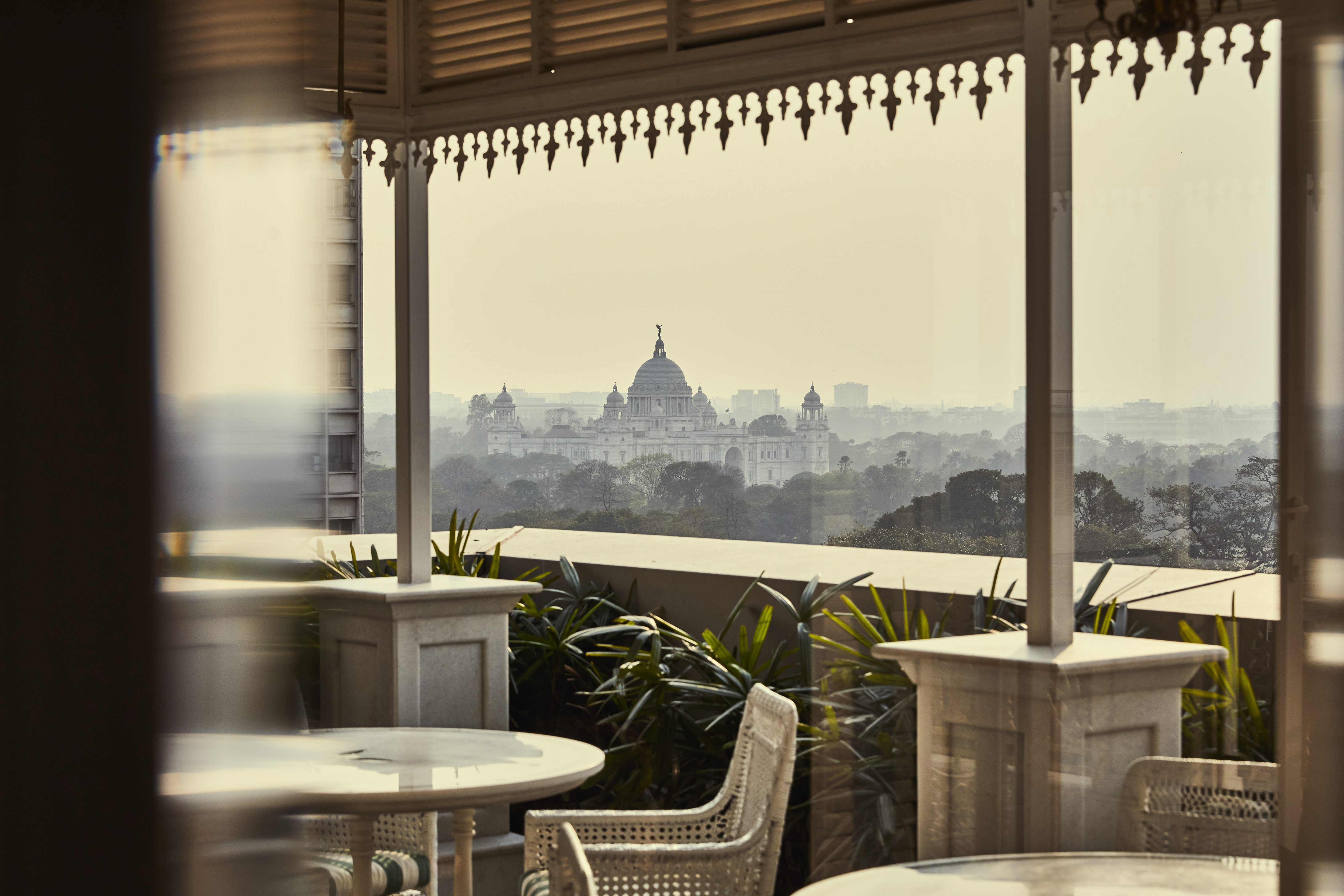 View of Kalkota through the window to the balcony featuring pillars and rattan furniture at Glenburn Penthouse