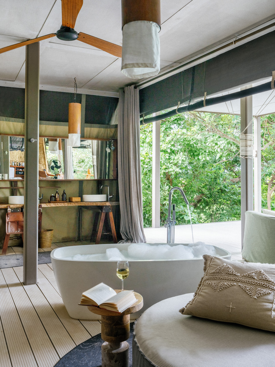 Africa, Zambia, Time + Tide Chinzombo, in room bath set up with a glass of white wine and an open book