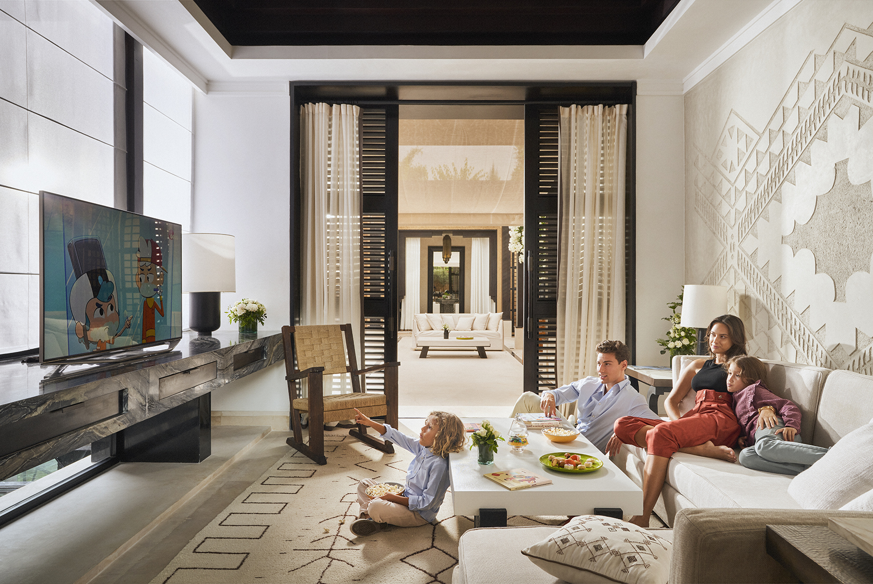 Africa, Morocco, Mandarin Oriental Marrakech, a family watching television together in a villa living room