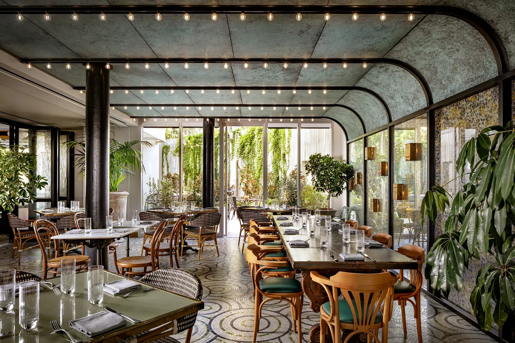 Elegant Lumière restaurant solarium at Fairmont Century Plaza in Los Angeles featuring lush greenery, natural light, and stylish bistro‑style dining.