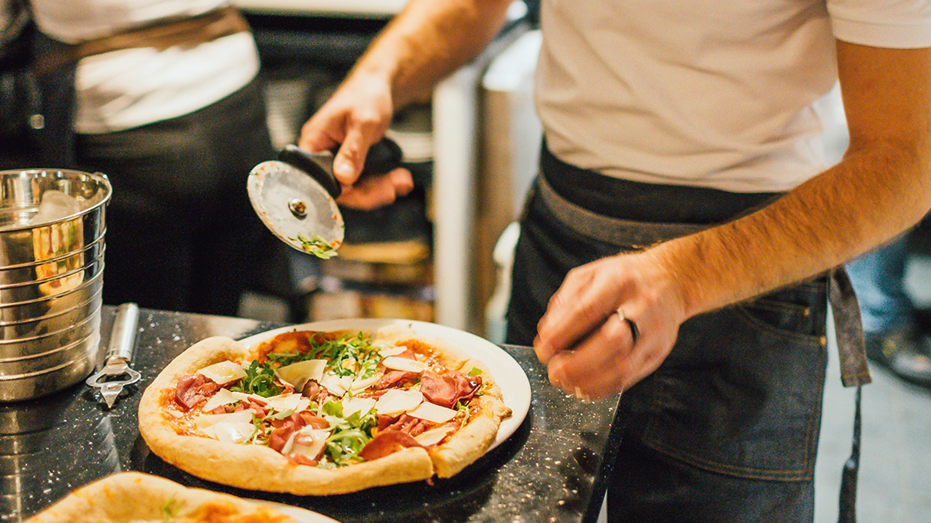 A person cutting a pizza