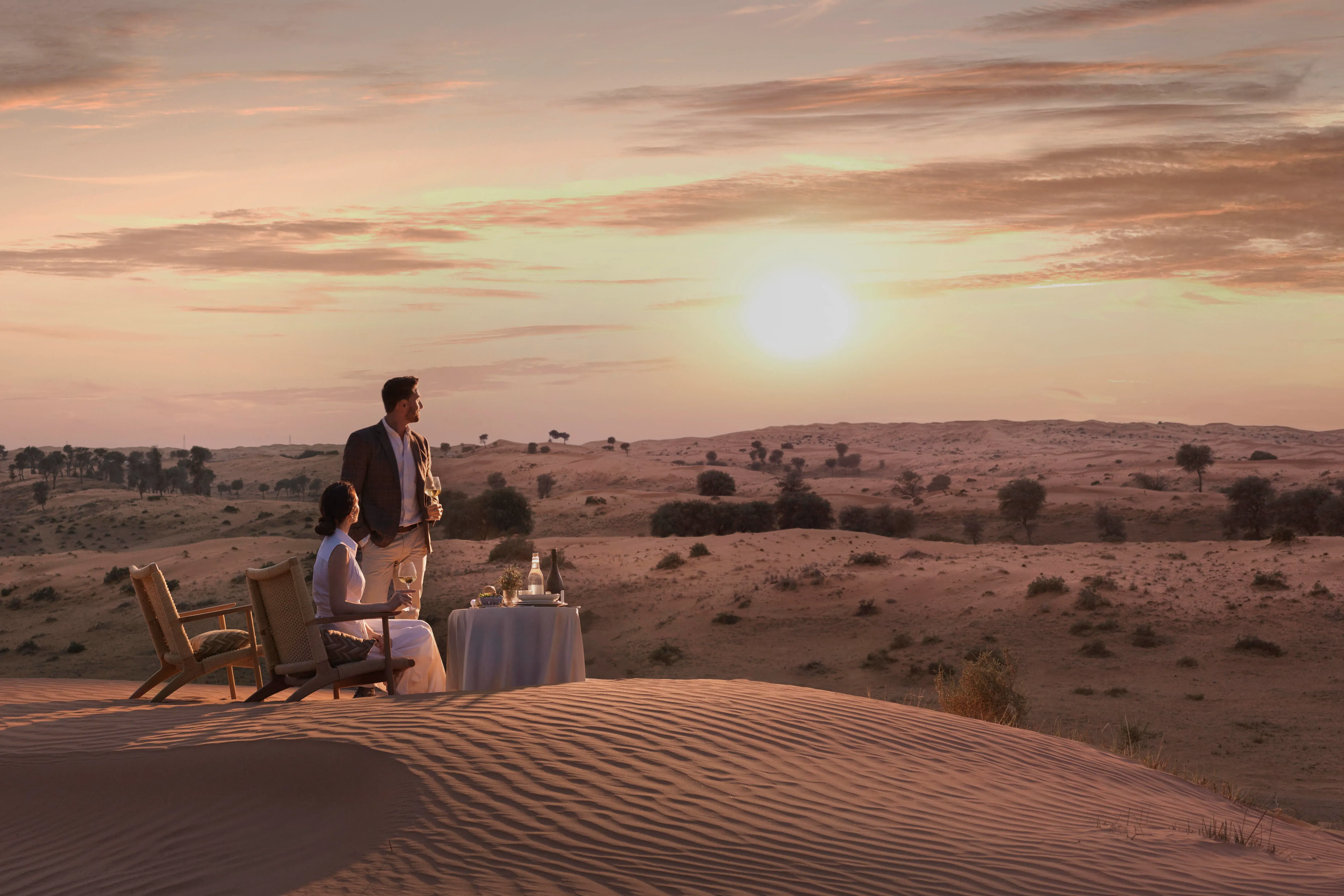 Romantic private dining experience at sunset in the desert at The Ritz-Carlton Ras Al Khaimah, Al Wadi Desert.
