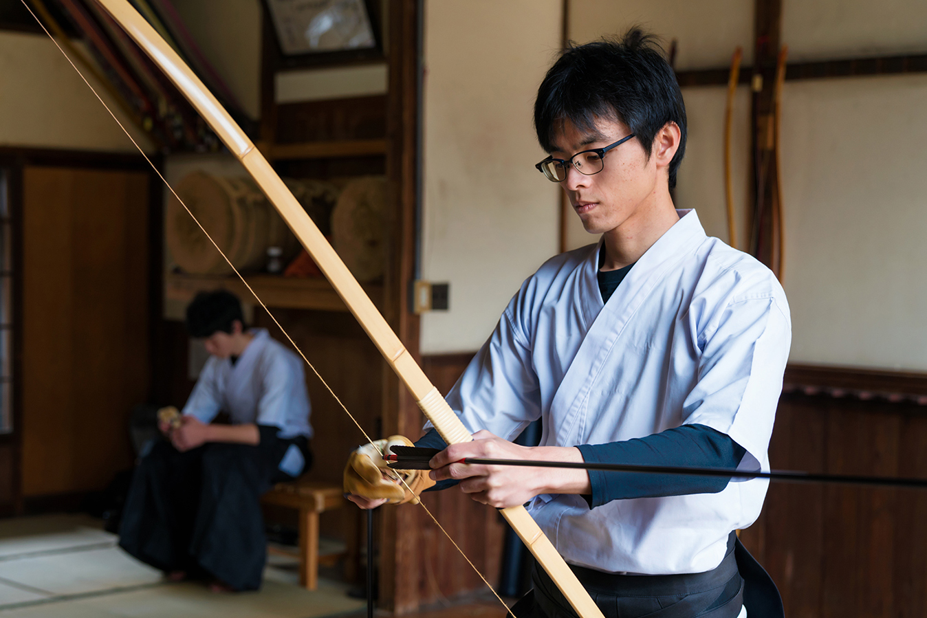 Young man preparing a bow and arrow for Japanese archery