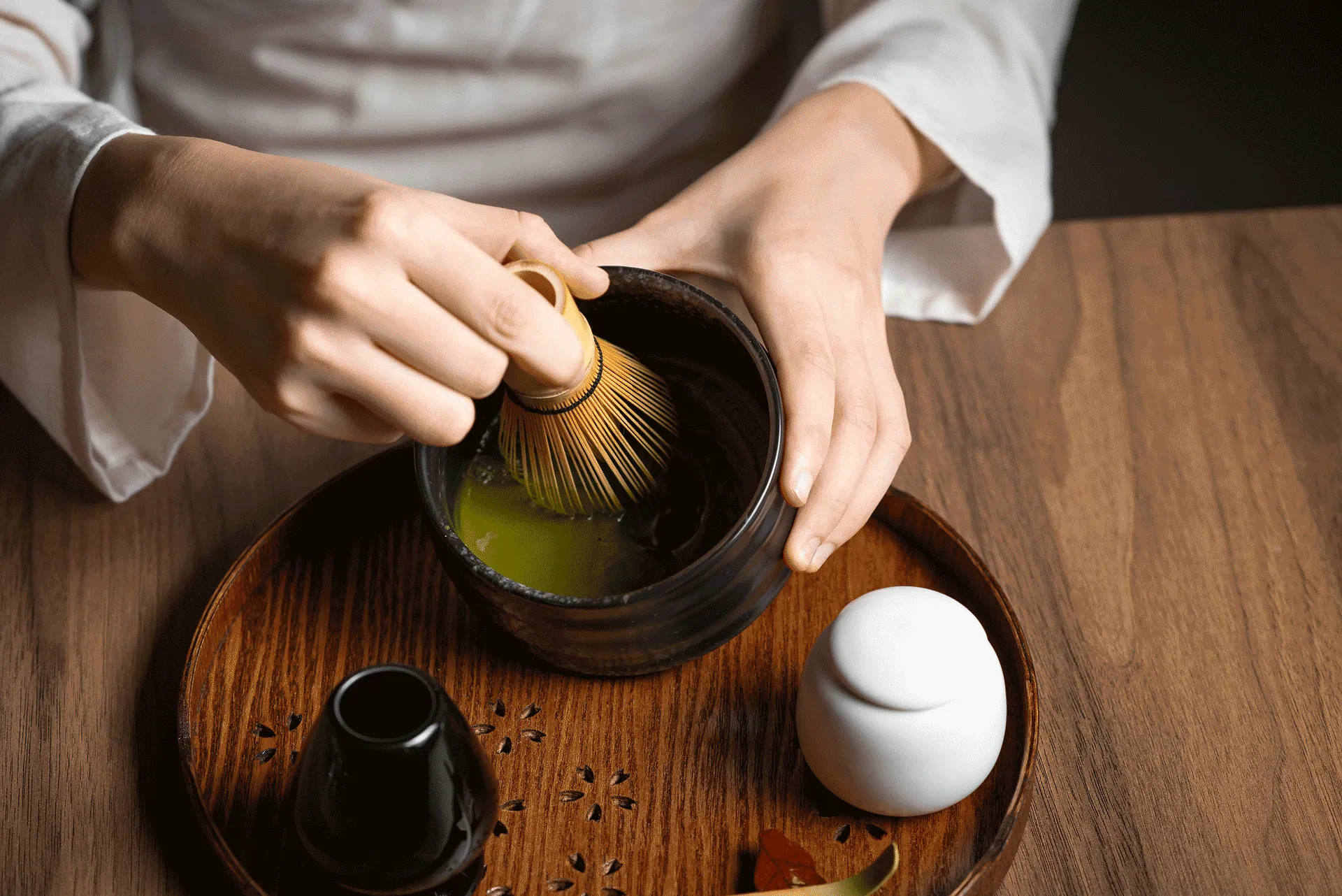 A close up image of a woman's hands performing a Japanese tea ceremony