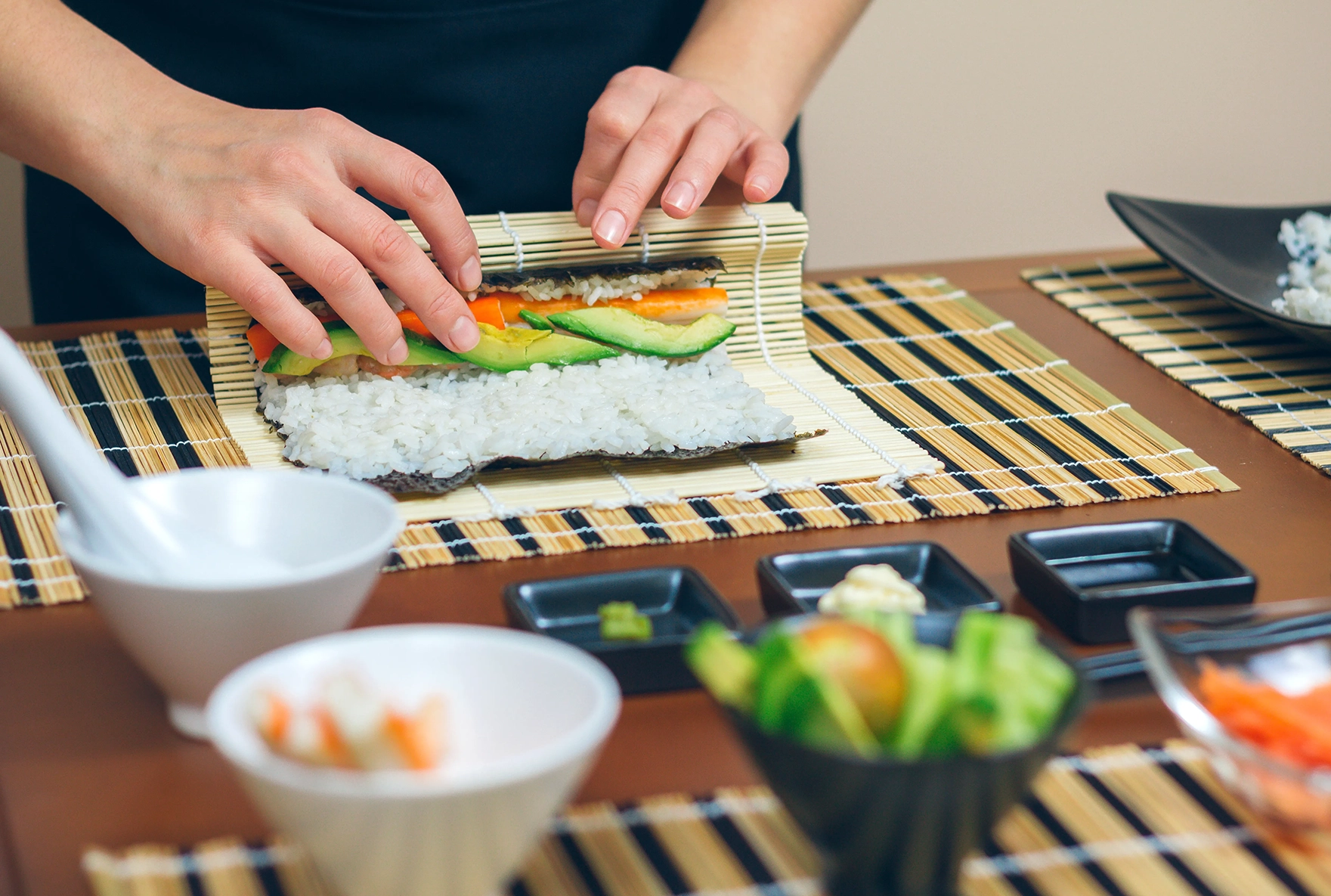 A person rolling sushi in a sushi making workshop