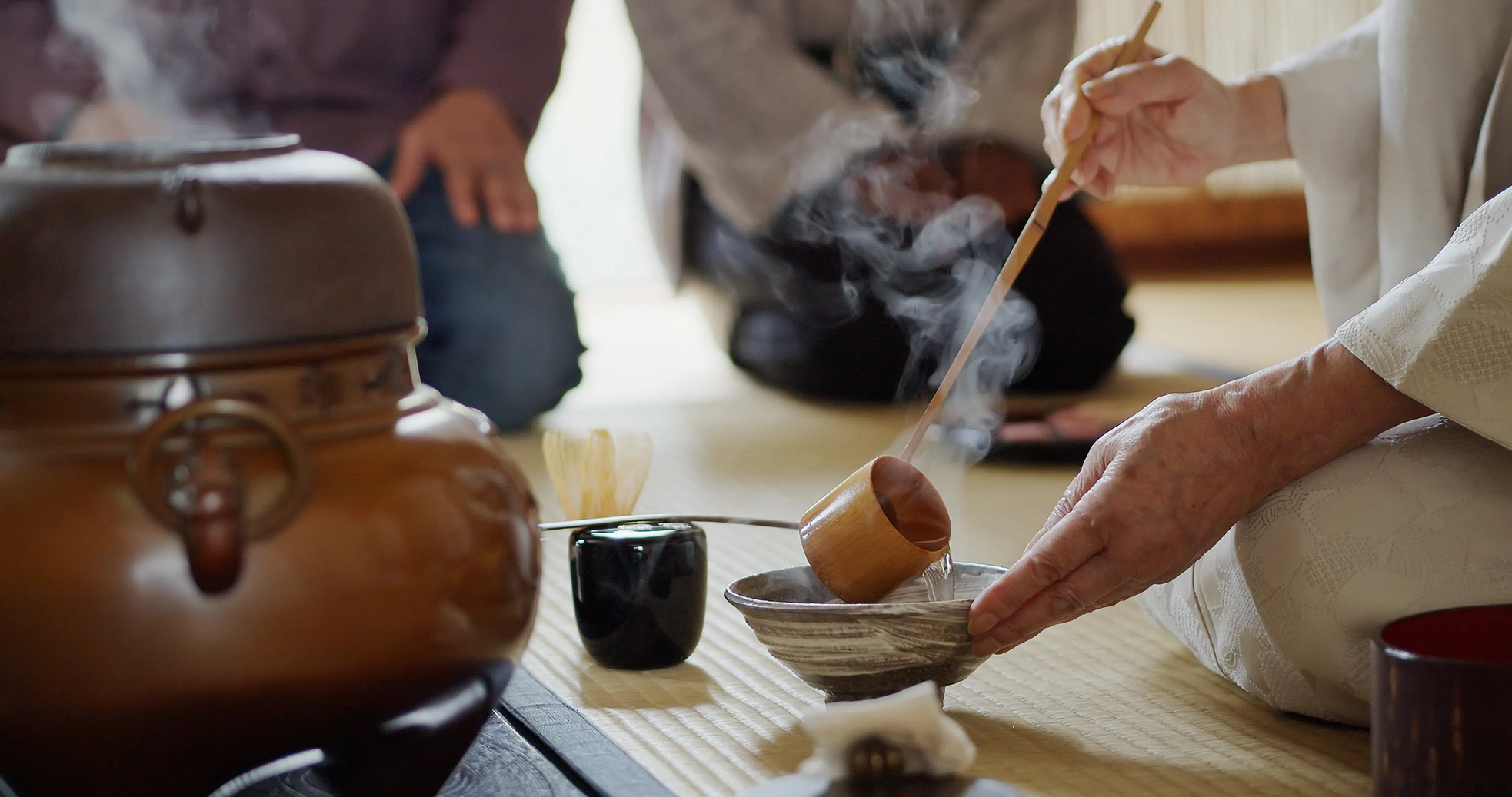 Two people watching a traditional Japanese tea ceremony