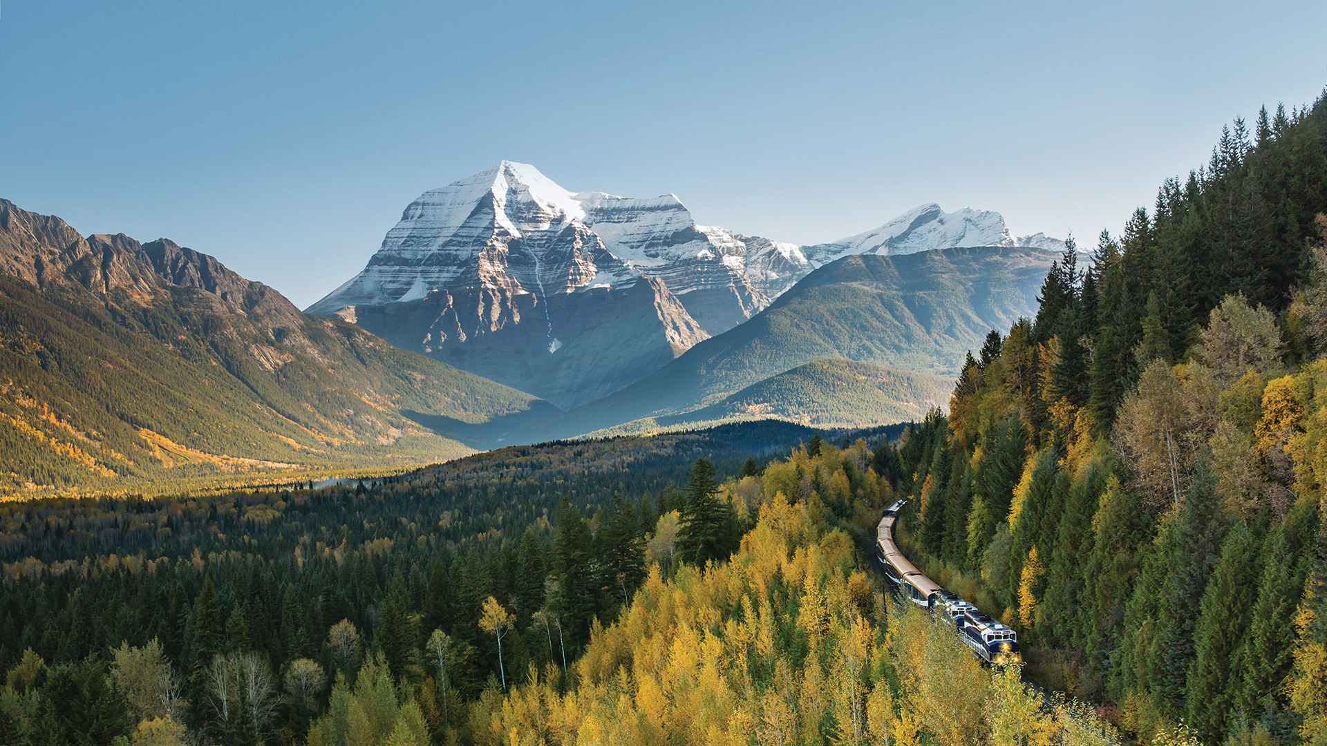 A Rocky Mountaineer train with  Mount Robson in the background, the  highest point in the Canadian Rockies
