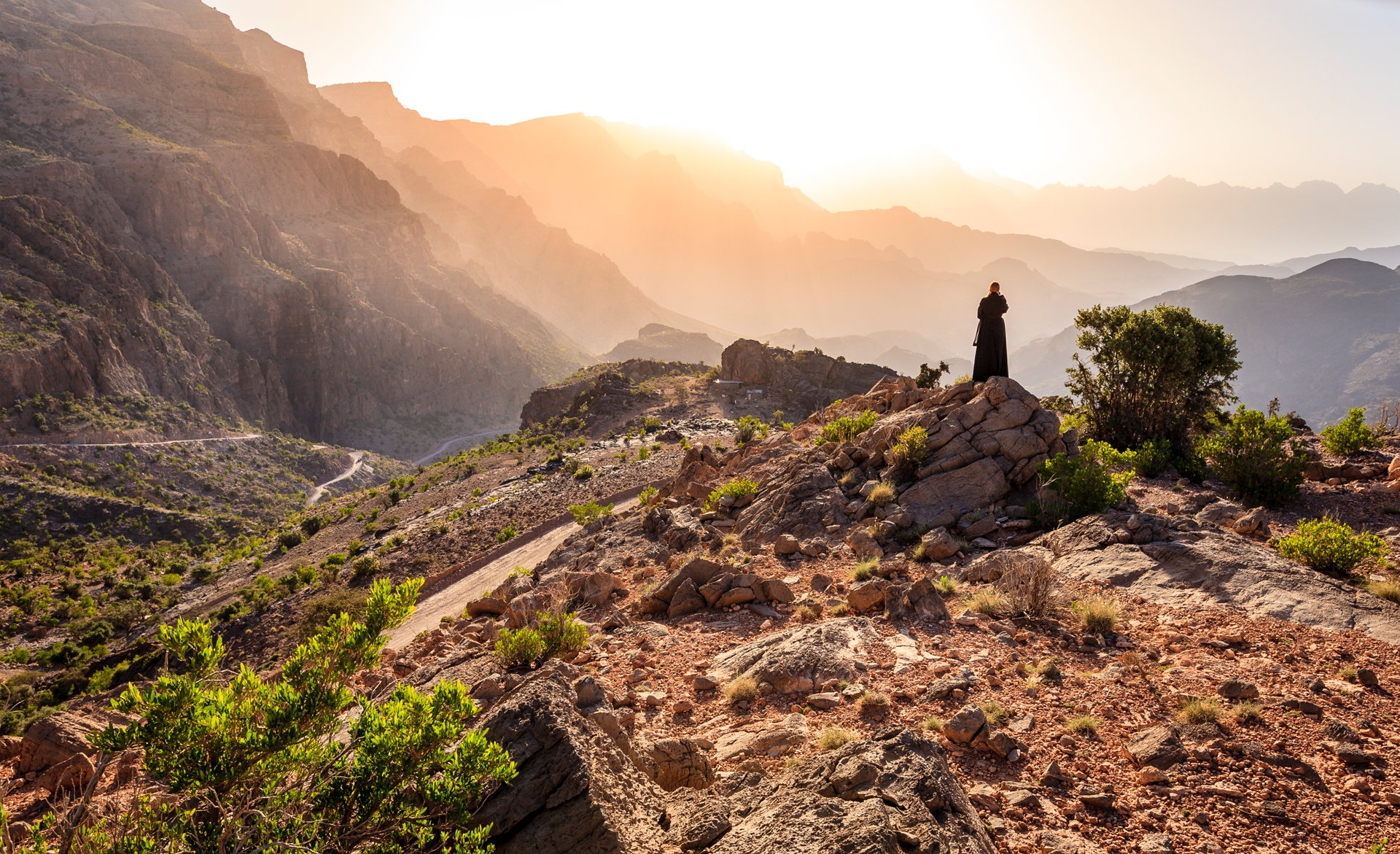 A person standing atop a rock mountain