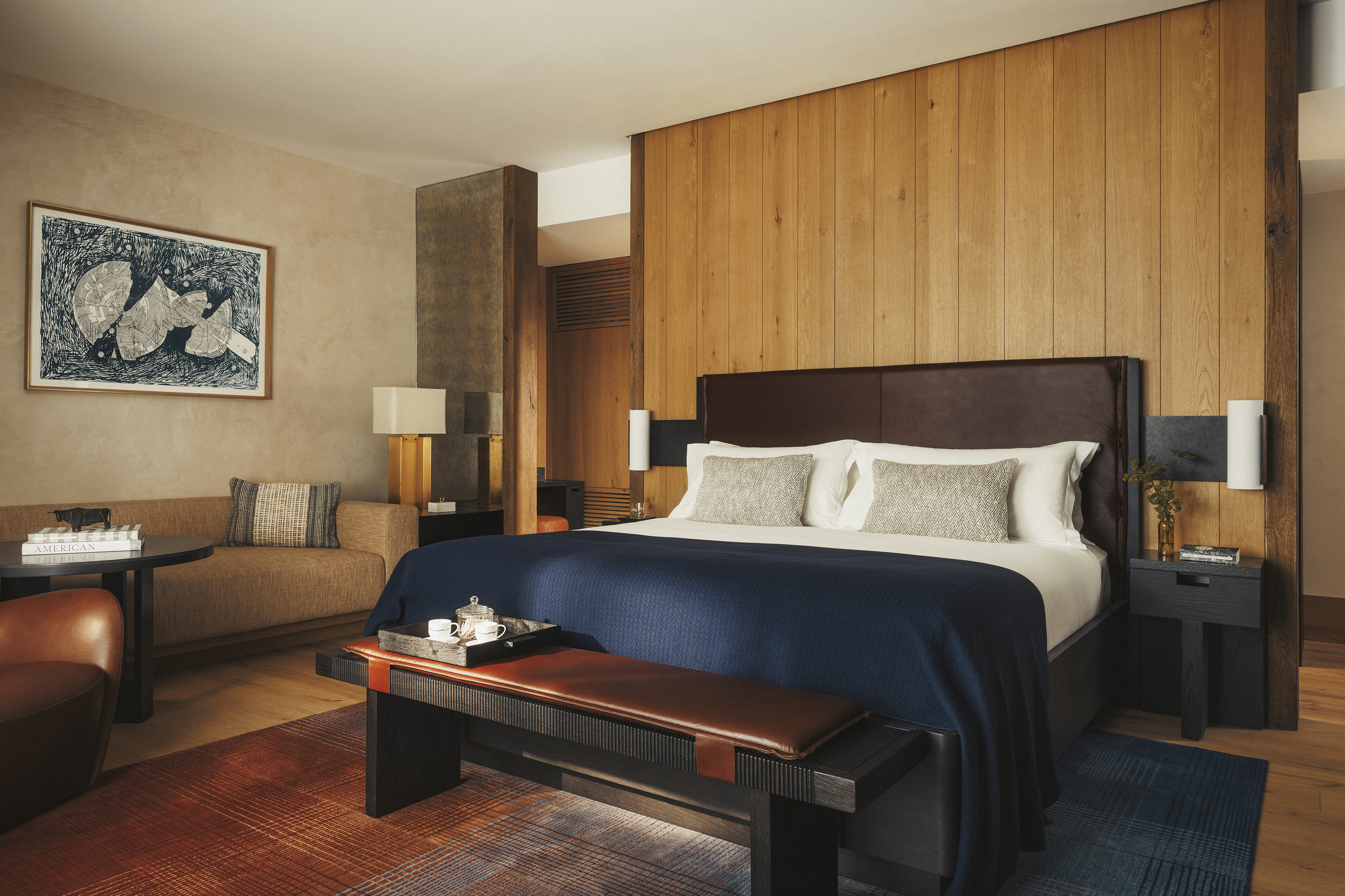 A stylish suite featuring deep wood furniture with blue soft furnishings 